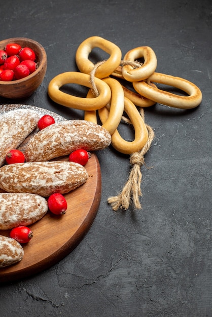 Vue verticale de délicieux biscuits à la banane avec des fruits sur un plateau en bois brun sur table noire