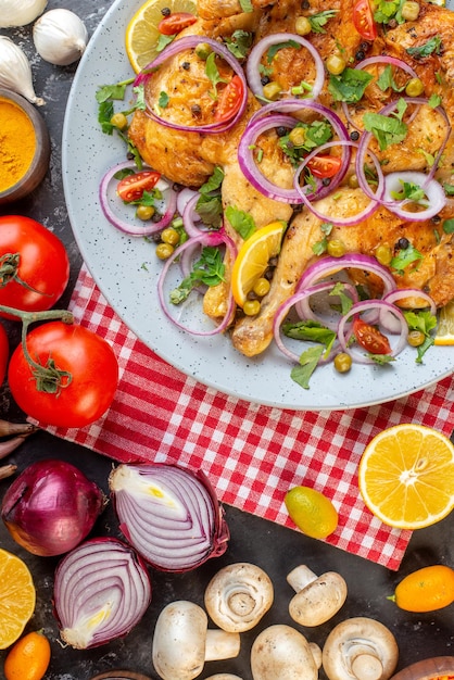 Vue verticale d'un délicieux plat de poulet frit au dîner avec diverses épices et aliments ail bouteille d'huile tombée citron sur fond de couleur sombre