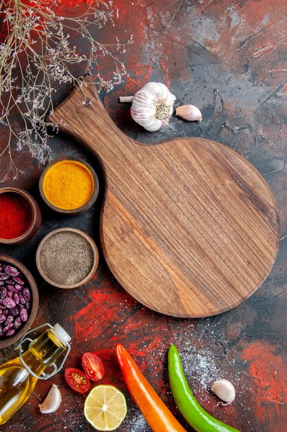 Vue verticale du dîner fond bouteille d'huile tombée haricots planche à découper et différentes épices