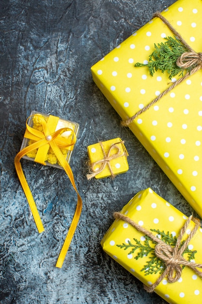 Vue verticale du fond de Noël avec des coffrets cadeaux jaunes pour les membres de la famille sur fond sombre