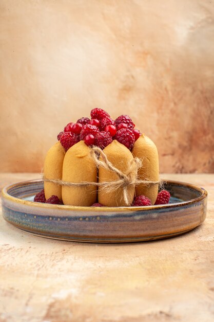 Vue verticale du gâteau moelleux fraîchement cuit avec des fruits sur fond de couleur mixte