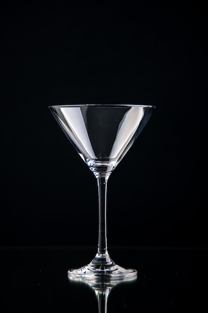 Photo gratuite vue verticale du gobelet en verre pour le vin debout sur fond noir