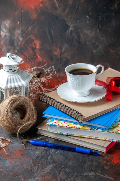 Vue verticale des fournitures de bureau et stylo conifère limes cannelle et une tasse de thé une boule de corde sur fond sombre