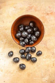 Vue verticale de raisins noirs frais tombés d'un petit pot