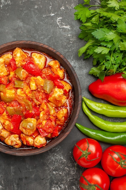 Vue verticale de la soupe de poulet à la tomate et de différents légumes avec des verts