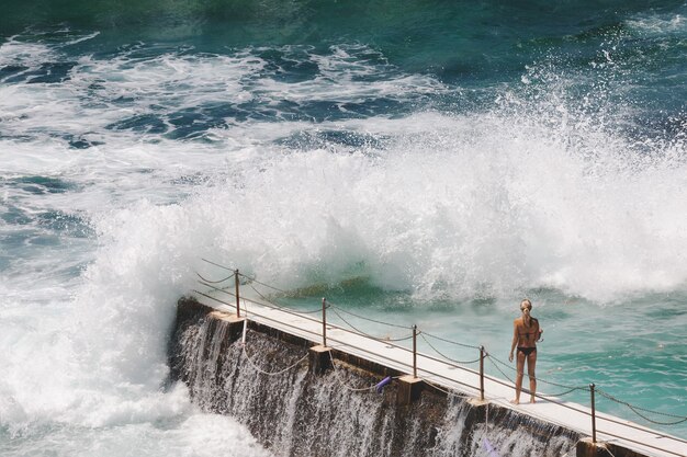 Vue à vol d'oiseau d'une femme blonde de race blanche en bikini noir à Bondi Beach, Sydney, Australie