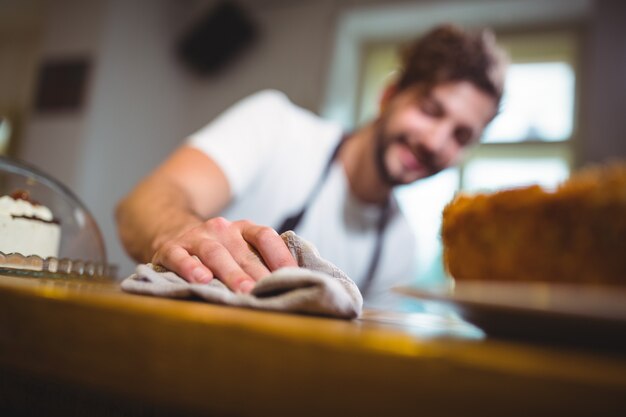 Waiter essuyant comptoir avec serviette en cafÃ ©