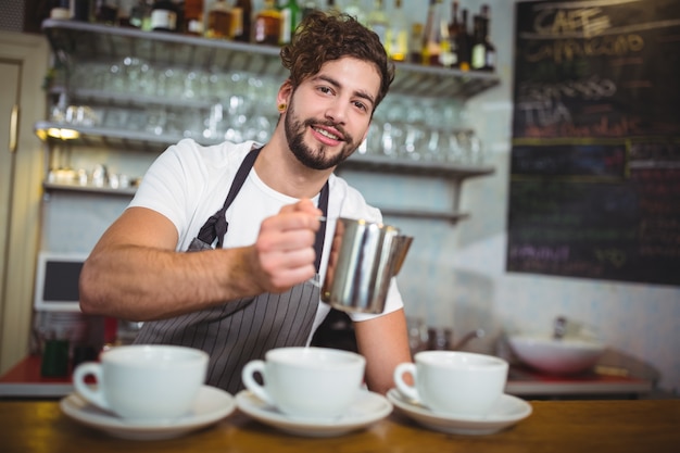 Waiter faisant tasse de café au comptoir dans le café