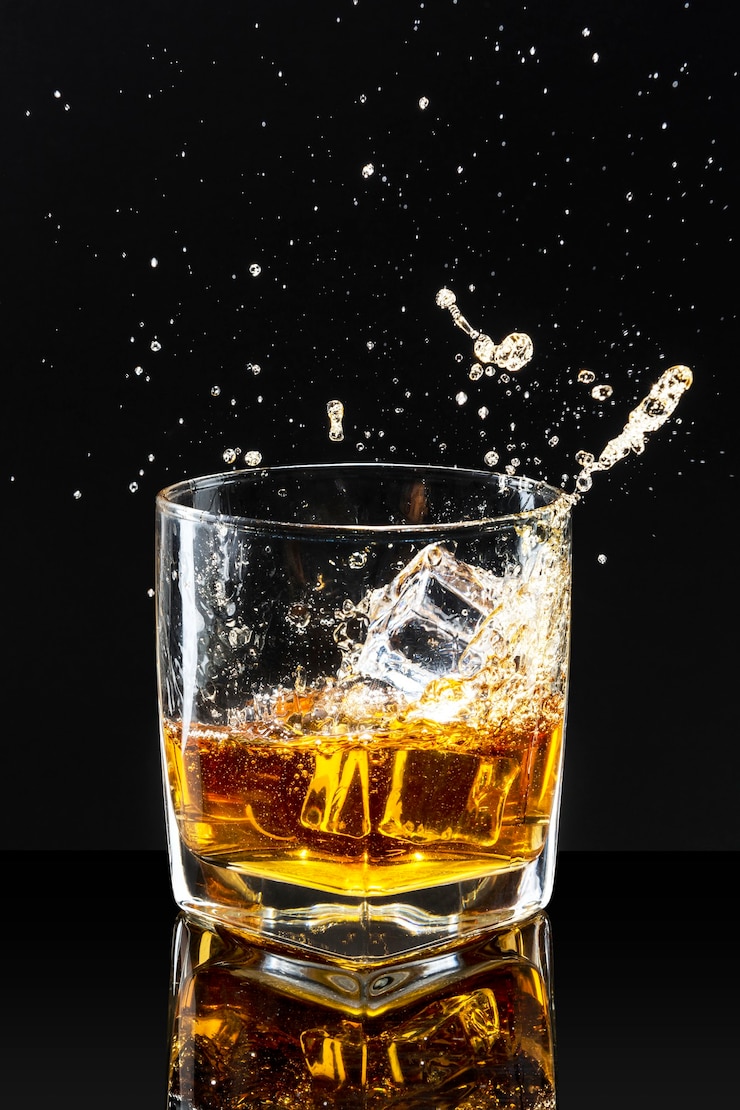 Photo gratuit whisky sur les rochers fond noir