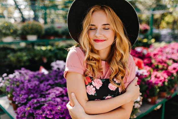 Winderful woman smiling avec les yeux fermés sur l'orangerie. Belle femme romantique debout en fleur de fleurs.