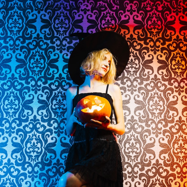 Photo gratuite witch girl holding pumpkin