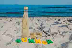 Photo gratuite word 'summer' et bouteille sur la plage