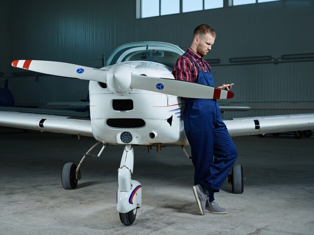 Workman avec smartphone et un avion