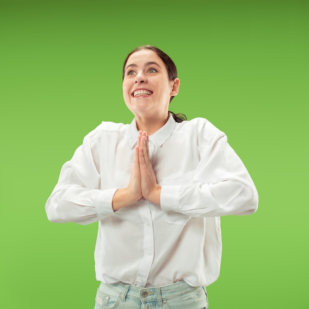 Wow. Beau portrait avant de femme demi-longueur isolé sur fond vert. Jeune femme surprise émotionnelle debout avec la bouche ouverte