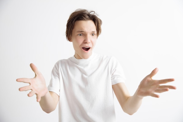 Wow. Portrait Avant Demi-longueur Mâle Attrayant Sur Fond De Studio Gris. Jeune Homme Surpris émotionnel Debout Avec La Bouche Ouverte. émotions Humaines, Concept D'expression Faciale