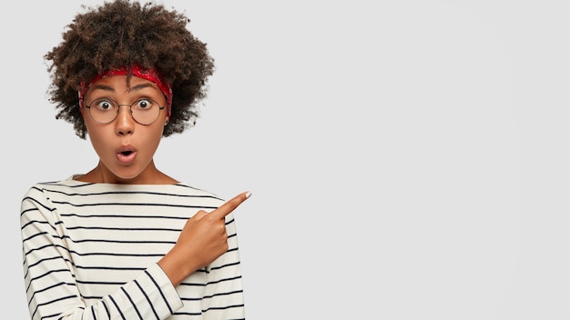 Photo gratuite wow, regardez cette chose incroyable! portrait de femme à la peau foncée choquée empêche la mâchoire de surprendre