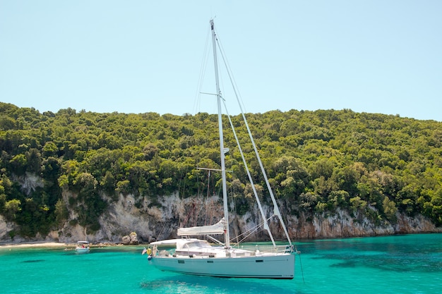 Yacht blanc naviguant dans le lagon turquoise par une journée ensoleillée