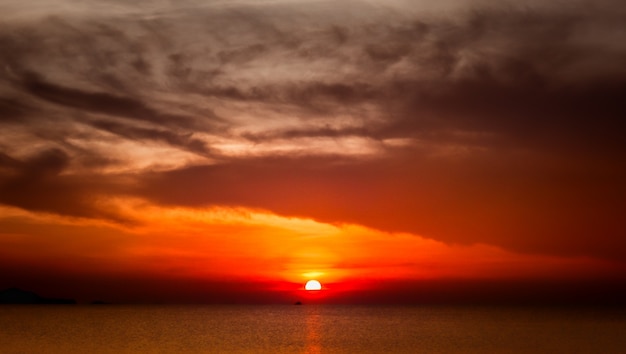 Photo gratuite yacht naviguant contre le coucher du soleil rouge complet. paysage de mode de vie avec horizon.