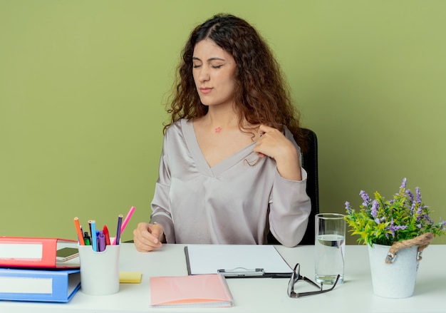 Avec les yeux fermés jeune jolie employée de bureau assise au bureau