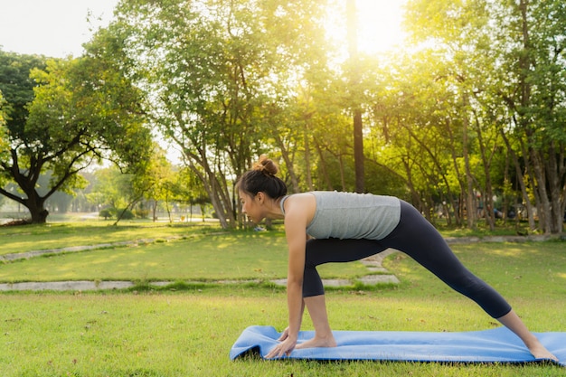 Yoga de jeune femme asiatique à l&#39;extérieur garder son calme et médite tout en pratiquant le yoga