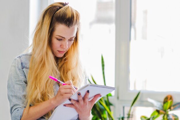 Young girl writing in notepad