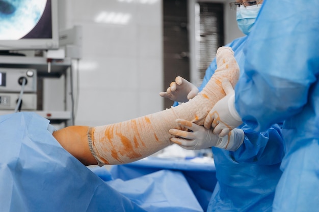 02024 Vinnytsia Ukraine deux chirurgiens de traumatologie travaillent sur la reconstruction de l'articulation du genou d'un patient sur la table d'opération