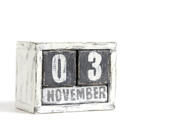 Photo 03 novembre sur le calendrier en bois sur fond blanc