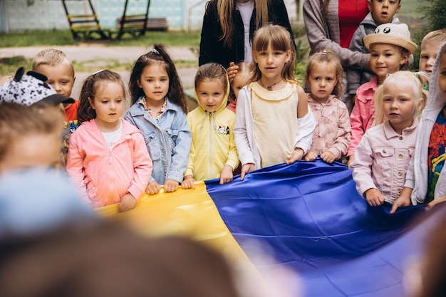 070722 Irpin Ukraine portraits d'enfants tenant un grand drapeau ukrainien et chantant des chansons patriotiques