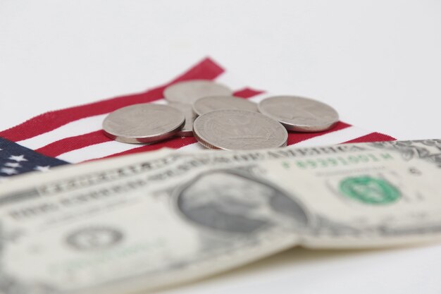 1 billet d'un dollar des États-Unis avec des pièces de monnaie et un drapeau en bas