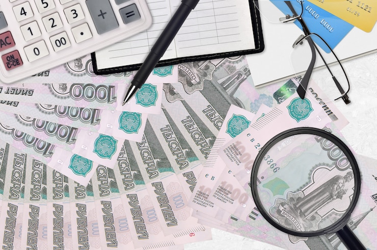 Photo 1000 factures de roubles russes et calculatrice avec lunettes et stylo. concept de saison de paiement des impôts ou solutions d'investissement. rechercher un emploi avec un salaire élevé