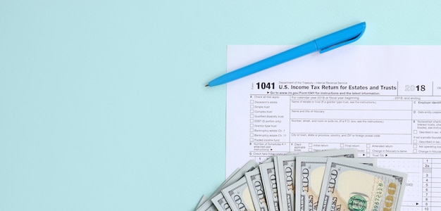 1041 formulaire d&#39;impôt se trouve près de cent dollars et stylo bleu