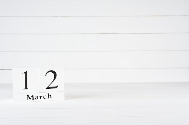 12 mars, jour 12 du mois, anniversaire, anniversaire, calendrier de bloc en bois sur un fond en bois blanc avec espace de copie du texte.