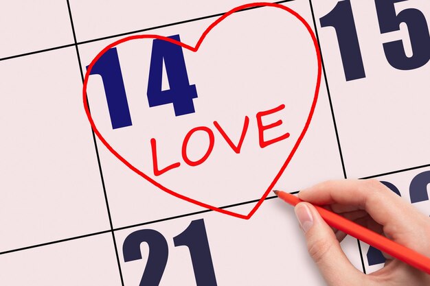 14e jour du mois Texte écrit à la main AMOUR et dessin d'un coeur rouge sur une date de calendrier rose