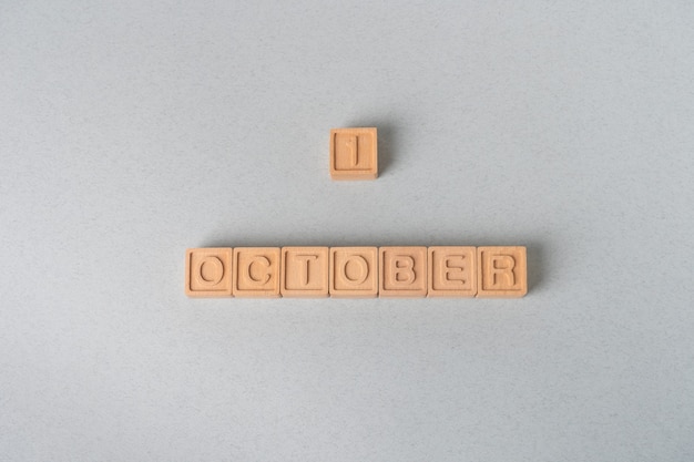 1er octobre mots sur des cubes en bois sur fond de papier bleu