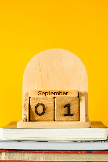 1er septembre sur un calendrier en bois parmi les manuels à étudier sur fond jaune