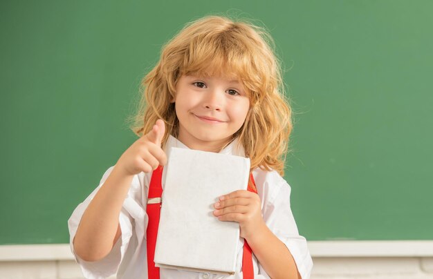 1er septembre. Développement de l'enfance. enfant avec livre. pointer du doigt. heureux adolescent en classe.