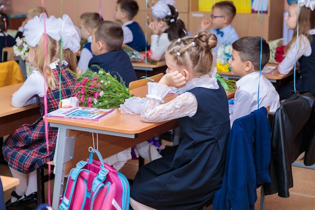 Le 1er septembre, les enfants s'assoient à leur bureau en classe. Les élèves de première année écoutent attentivement.