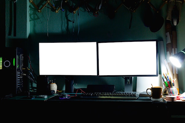 2 écrans d'ordinateur sur le bureau la nuit