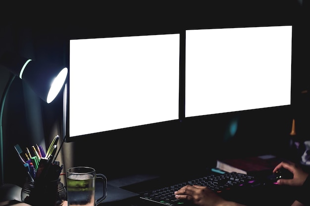 2 écrans d'ordinateur sur le bureau la nuit