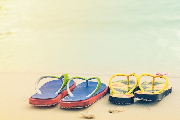 2 pantoufles sur la plage de sable blanc, voyage et vacances