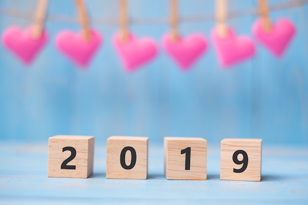 2019 cubes en bois avec décoration forme coeur rose sur fond de table bleue et espace copie pour le texte. Affaires, Résolution, Nouvel An Nouveau Vous et Happy Valentine&#39;s Day concept