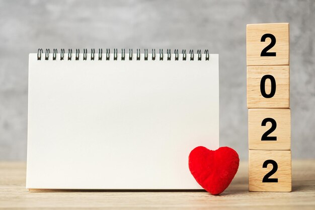 2022 cubes avec forme de coeur rouge et cahier vide sur table pour votre texte. Nouvel An, Résolution, Objectif, plan, santé, Amour et Happy Valentine day concept