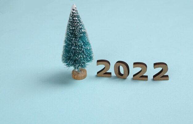 2022 et mini sapin de noël sur fond bleu composition du nouvel an de noël