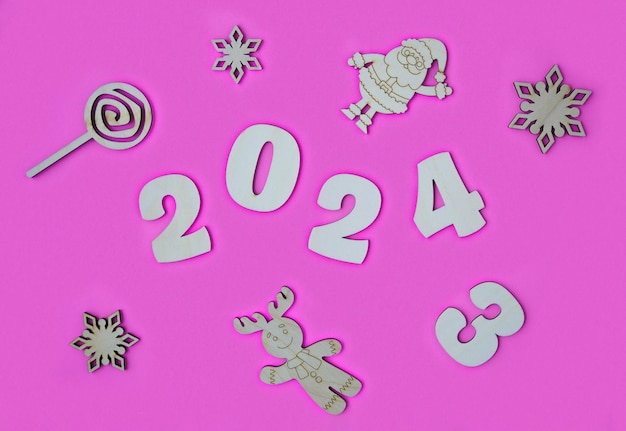 Photo de 2023 à 2024 numéros en bois sur un fond rose concept midyear