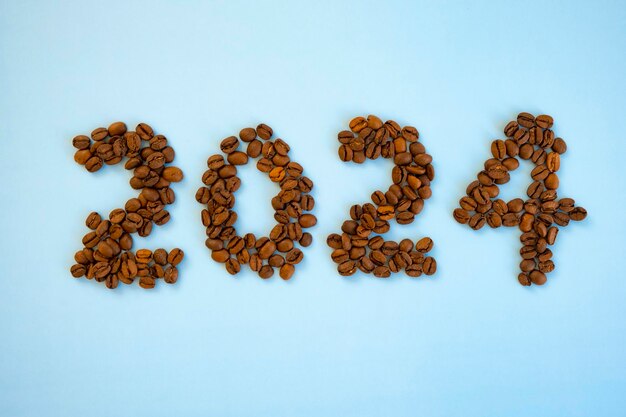 Photo 2024 numéro fait de grains de café et une tasse de café bonne année et joyeux noël