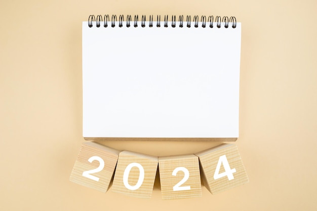 Photo 2024 time for new start white paper and 2024 cubes wooden table background new year plans for 2024 blank space on notepad mockup calendar start new year 2024 with goal plan