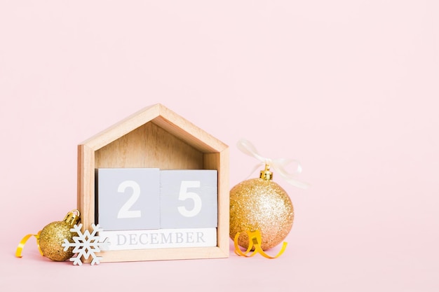 25 décembre composition de Noël sur fond coloré avec un calendrier en bois avec une boîte-cadeau jouets babiole copie espace