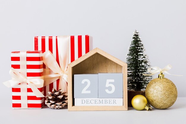 25 décembre composition de Noël sur fond coloré avec un calendrier en bois avec une boîte-cadeau jouets babiole copie espace