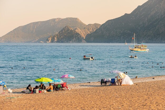 Photo 29 août 2021 cirali turquie les vacanciers prennent le soleil et nagent sur la plage de cirali en turquie avec une vue sur les chaînes des montagnes du taurus