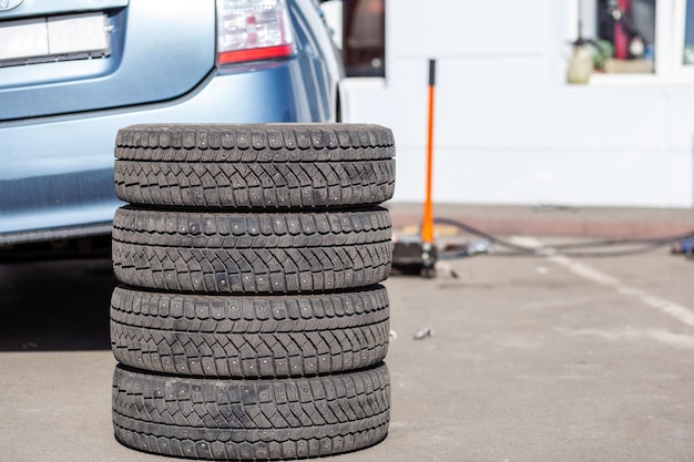 4 pneus d'hiver à remplacer sur le fond de la voiture Remplacement des pneus lors d'un service de voiture